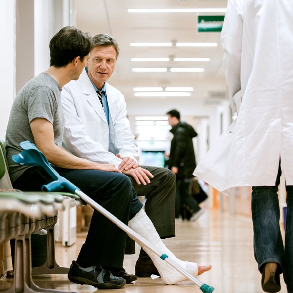 homme avec un pied dans le platre parle a son medecin